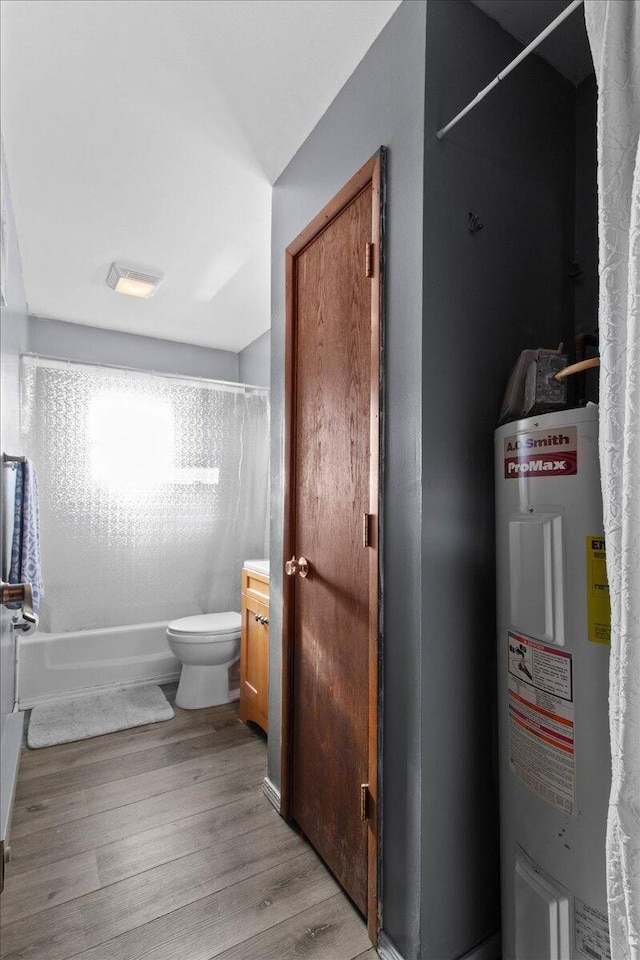 full bathroom with tub / shower combination, vanity, electric water heater, hardwood / wood-style flooring, and toilet