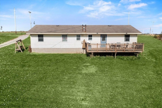 rear view of house with a lawn and a wooden deck