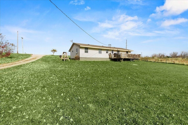 back of house featuring a lawn and a wooden deck