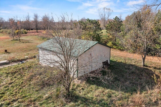 view of outdoor structure with a lawn and a rural view