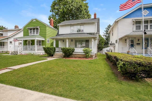 view of front of property with a porch, a shingled roof, and a front yard