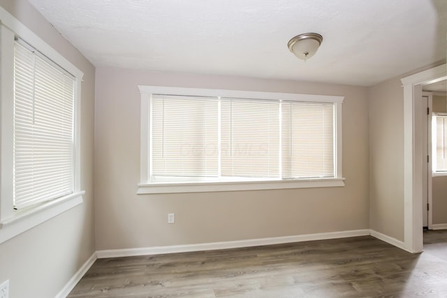 unfurnished room with baseboards and wood finished floors