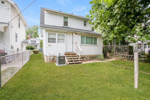 rear view of house featuring a fenced backyard, central AC unit, entry steps, and a yard