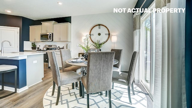 dining space with sink and light hardwood / wood-style flooring