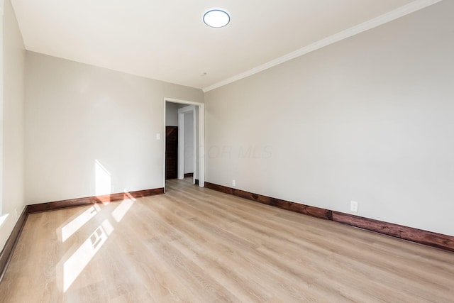 spare room with crown molding and light hardwood / wood-style flooring