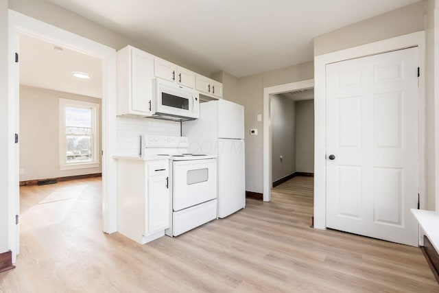 kitchen with backsplash, light hardwood / wood-style flooring, white cabinets, and white appliances