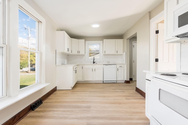 kitchen featuring tasteful backsplash, white appliances, sink, light hardwood / wood-style flooring, and white cabinetry