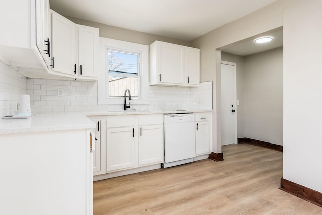 kitchen with dishwasher, backsplash, white cabinets, sink, and light wood-type flooring