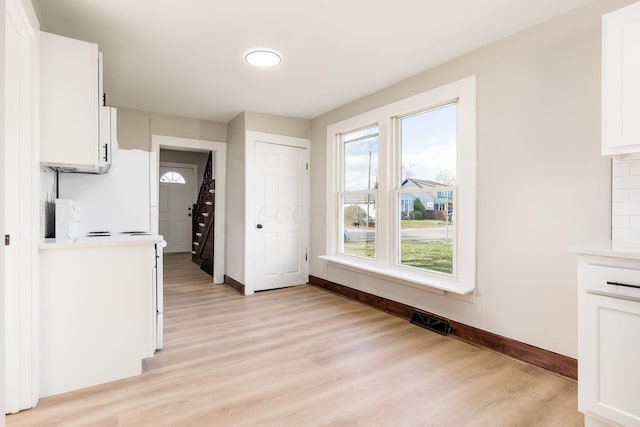 kitchen featuring white cabinets and light wood-type flooring