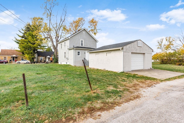 view of side of property with a lawn, a garage, and an outdoor structure