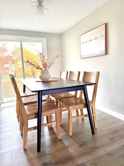 dining space with a notable chandelier and dark wood-type flooring