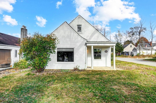 rear view of property featuring a lawn