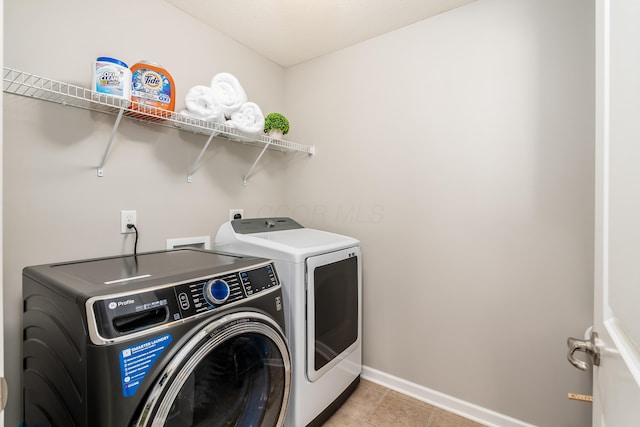 washroom featuring washer and clothes dryer and light tile patterned floors