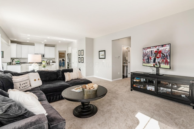 carpeted living room featuring sink