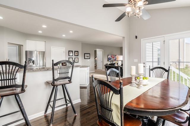 dining space with ceiling fan, high vaulted ceiling, and dark wood-type flooring