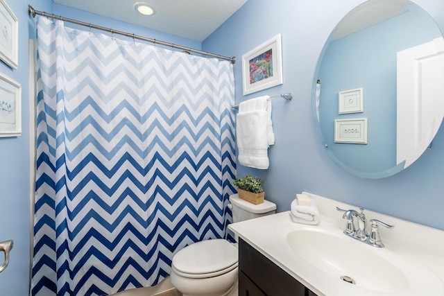 bathroom featuring vanity, curtained shower, and toilet