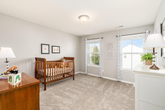 carpeted bedroom with a nursery area