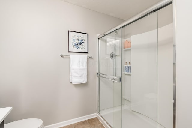 bathroom with tile patterned floors, vanity, toilet, and an enclosed shower