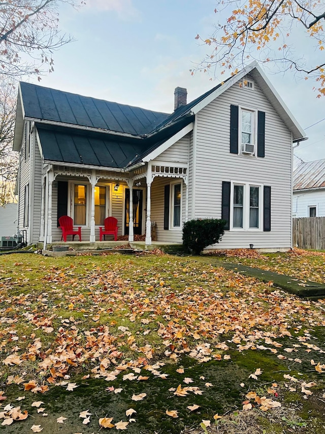 view of front facade featuring a front yard, a porch, and cooling unit