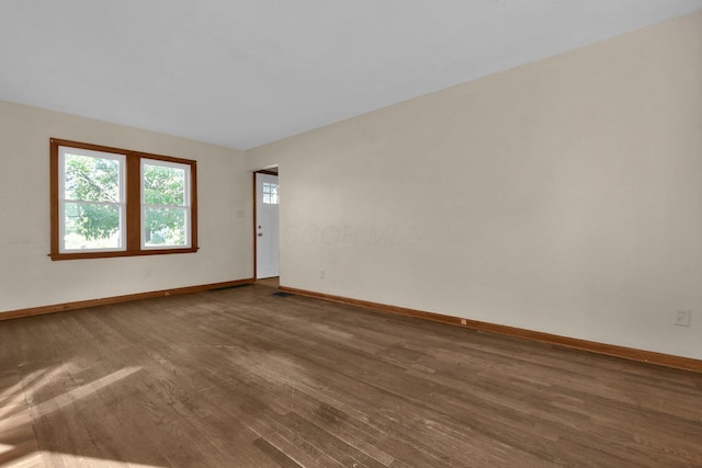 unfurnished room with dark wood-type flooring