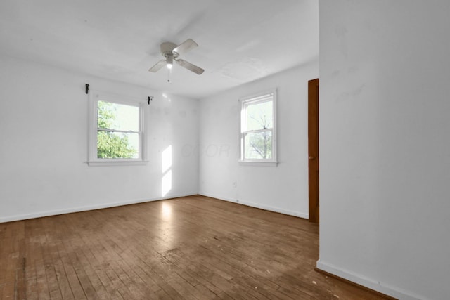 spare room featuring dark hardwood / wood-style floors, a wealth of natural light, and ceiling fan