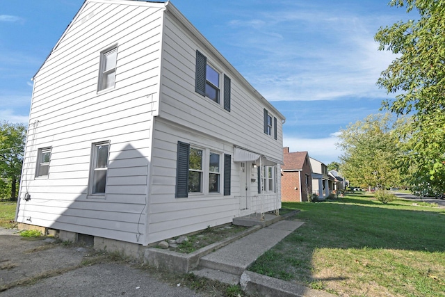 view of side of home with a yard