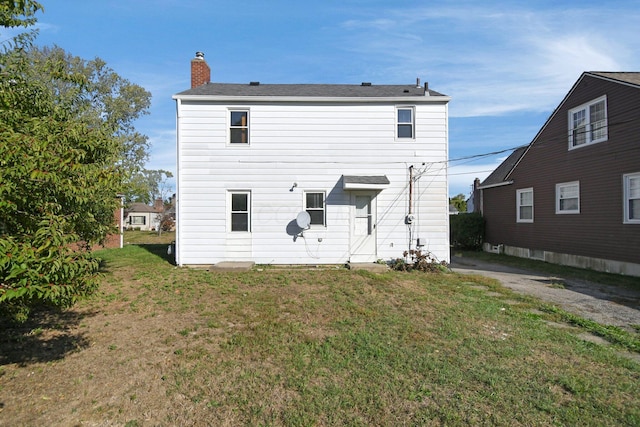 rear view of house featuring a lawn