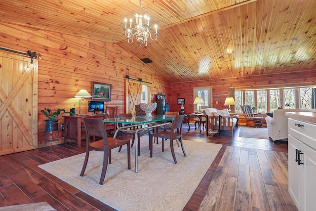 dining area featuring a barn door, dark hardwood / wood-style flooring, lofted ceiling, and wood ceiling