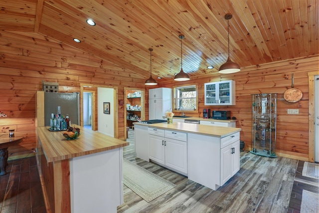 kitchen with pendant lighting, a kitchen island, white cabinets, and dark wood-type flooring