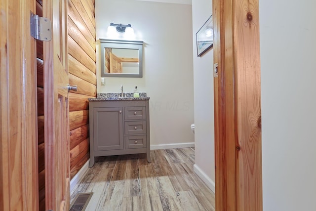 bathroom featuring hardwood / wood-style flooring, vanity, and toilet