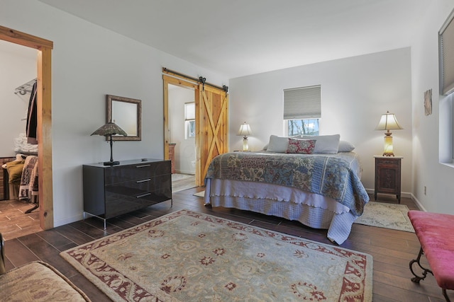 bedroom with a barn door and dark wood-type flooring