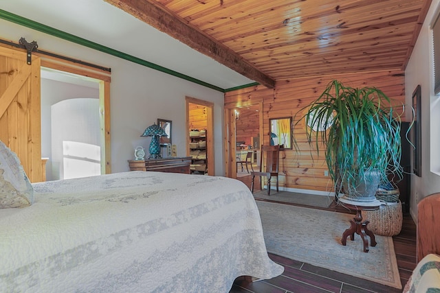 bedroom featuring wooden ceiling, a barn door, dark hardwood / wood-style flooring, beamed ceiling, and wooden walls