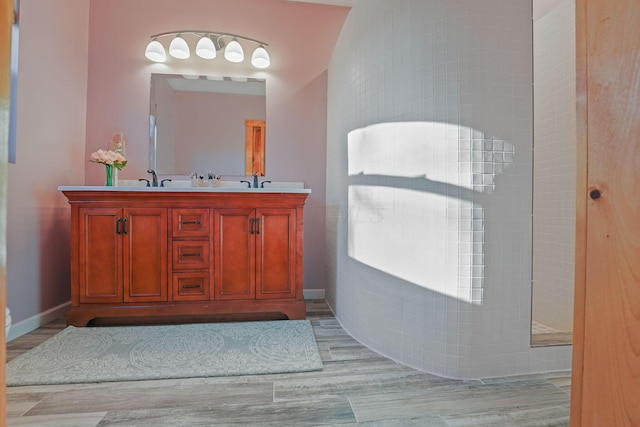 bathroom featuring a shower, wood-type flooring, and vanity