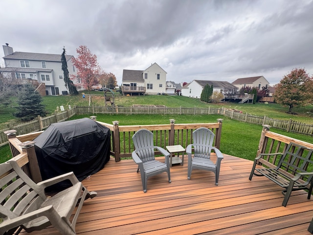 wooden deck featuring a grill and a yard