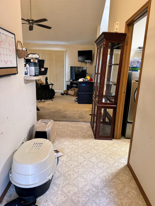 hallway with washer / dryer and light colored carpet