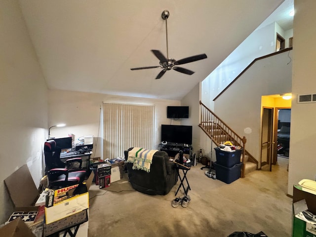 carpeted living room featuring ceiling fan and a towering ceiling