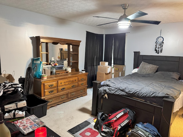 bedroom featuring carpet flooring, ceiling fan, and a textured ceiling