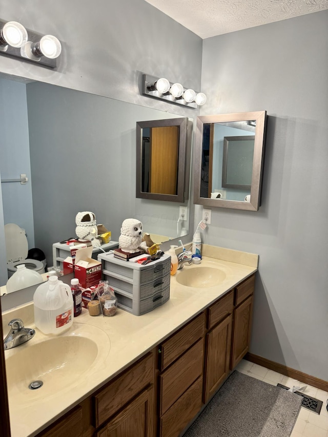 bathroom featuring a textured ceiling, vanity, and tile patterned floors