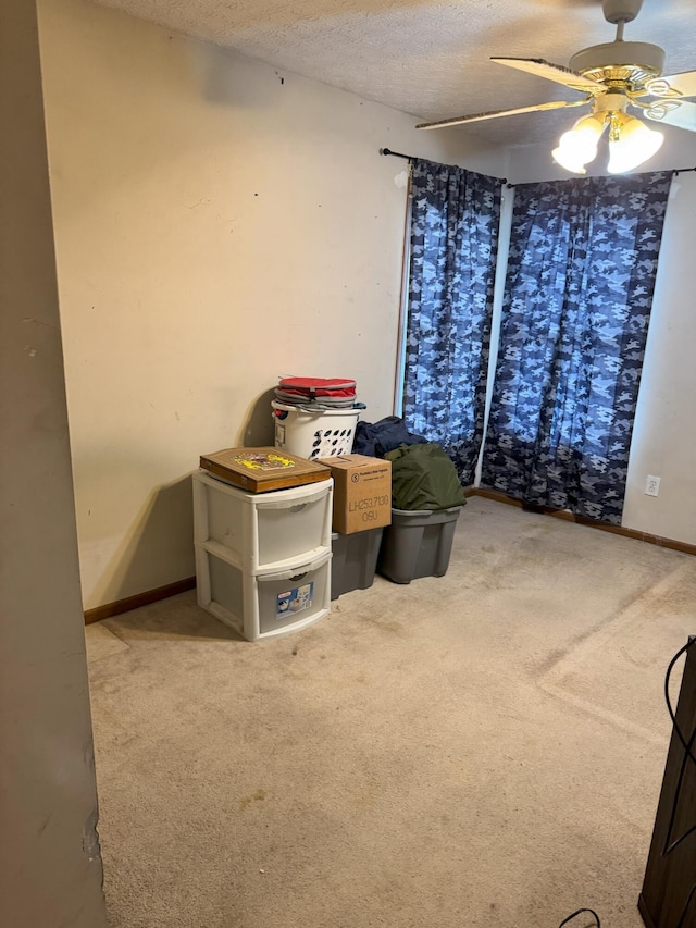 bedroom with a textured ceiling, light colored carpet, and ceiling fan