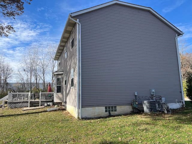 view of side of home featuring a wooden deck and a yard