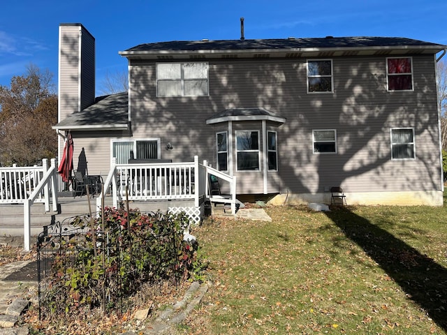 back of house featuring a deck and a lawn