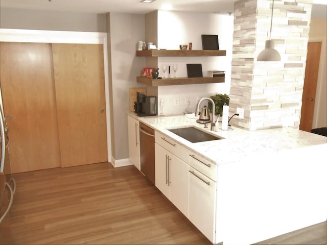 kitchen featuring white cabinets, light hardwood / wood-style floors, stainless steel dishwasher, and sink