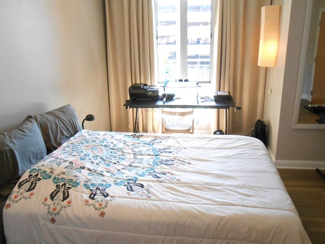 bedroom with dark hardwood / wood-style flooring