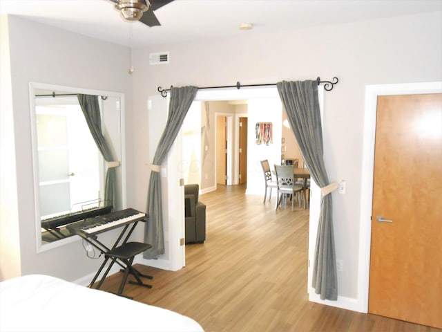 bedroom featuring hardwood / wood-style flooring and a barn door