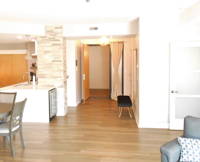 hallway featuring light hardwood / wood-style floors, sink, and wine cooler