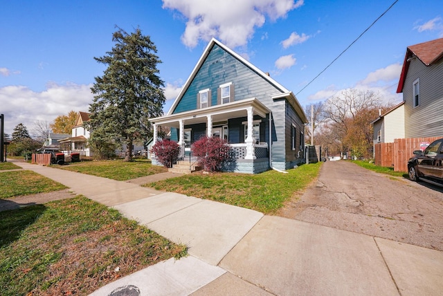 bungalow featuring covered porch and a front lawn