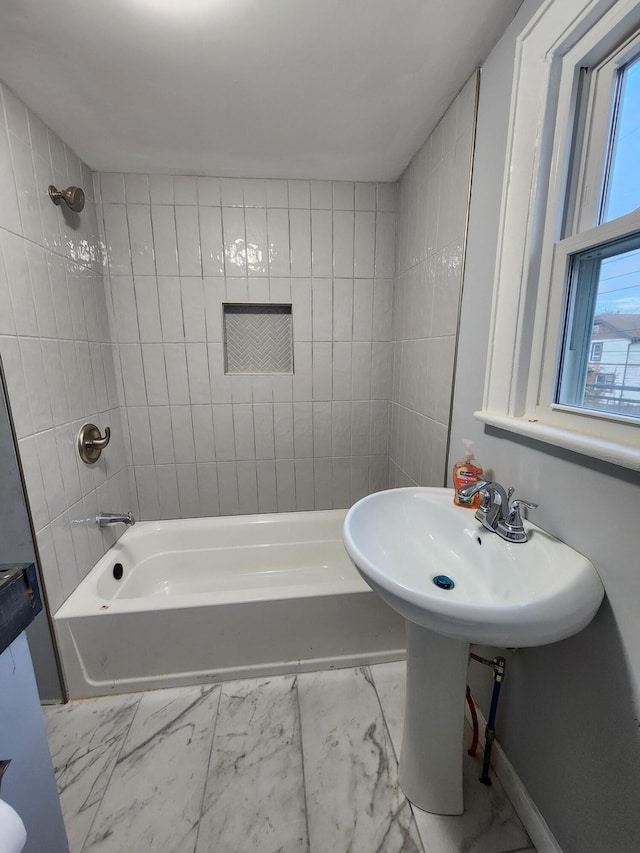 bathroom with baseboards, marble finish floor, and shower / bath combination