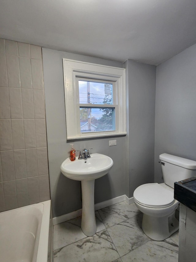 bathroom with a sink, baseboards, toilet, and marble finish floor