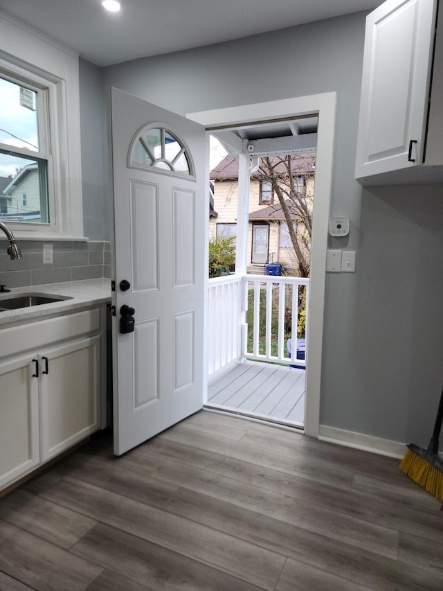 interior space with plenty of natural light, wood finished floors, baseboards, and a sink