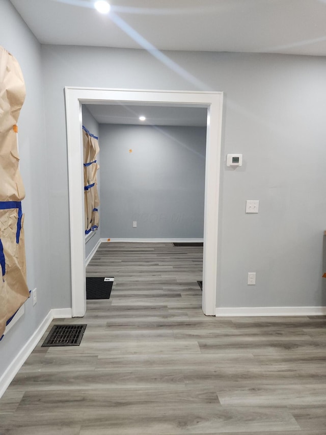 hall featuring recessed lighting, visible vents, baseboards, and wood finished floors